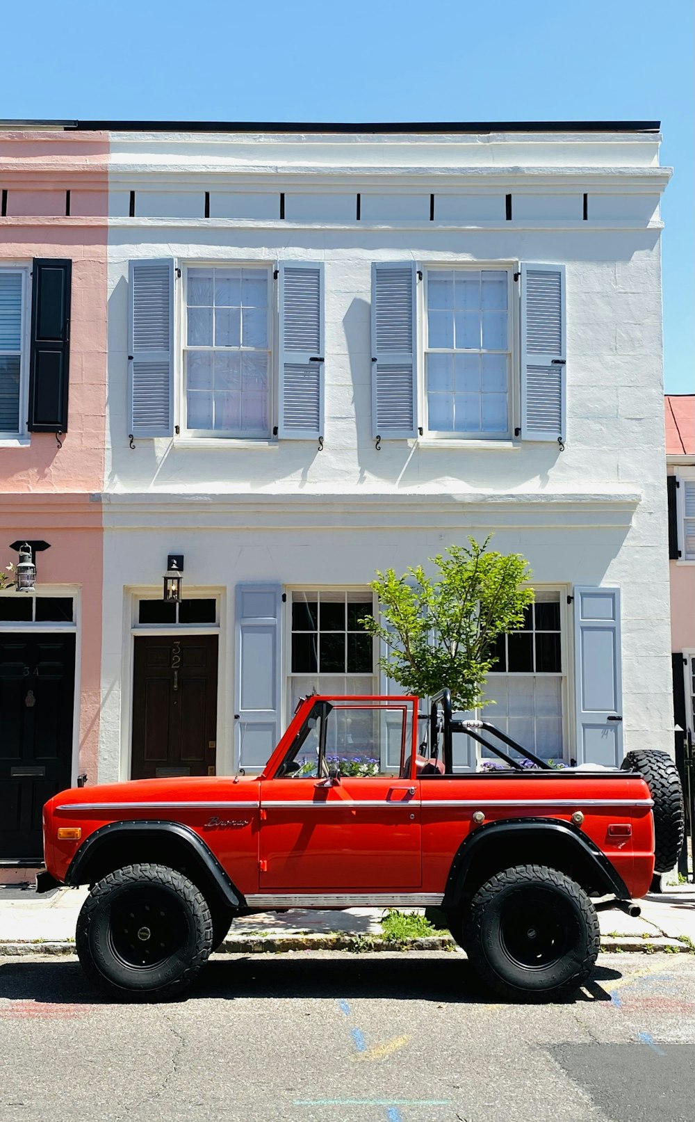 red car parked in front of white building