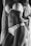 A grayscale photo features a woman wearing lace lingerie, accentuated with intricate patterns. She is posed with a hand on her hip and a draped, textured shawl over her shoulder, highlighting the curves and details of the design.