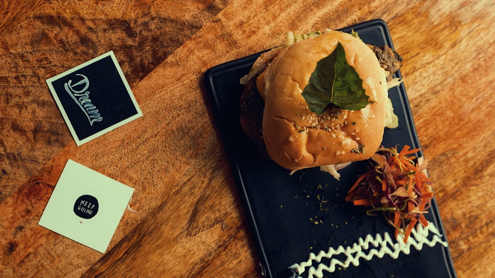burger on black tray on brown wooden table