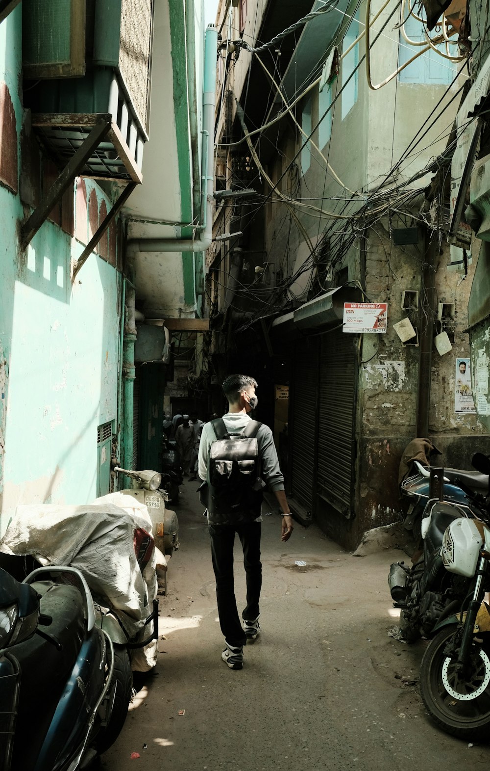 man in black jacket walking on street during daytime