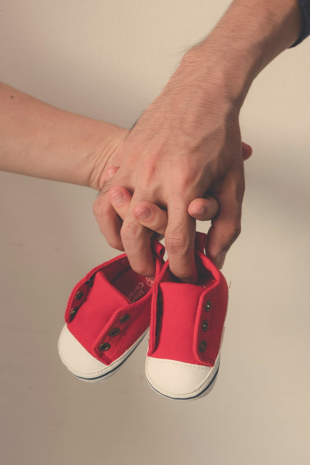 person holding red and white shoe