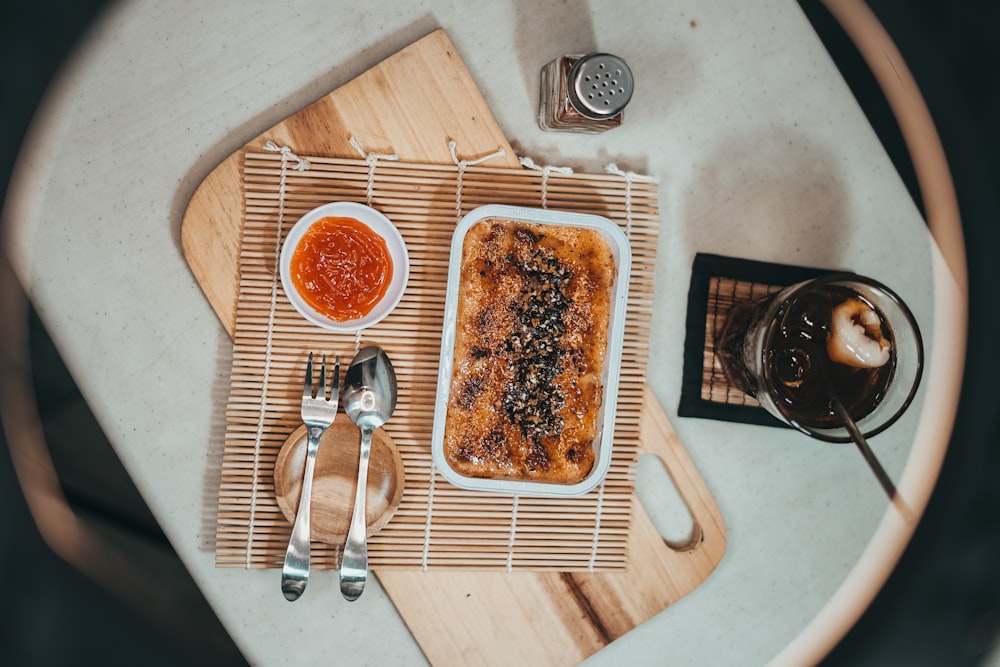 stainless steel spoon and fork on brown wooden chopping board