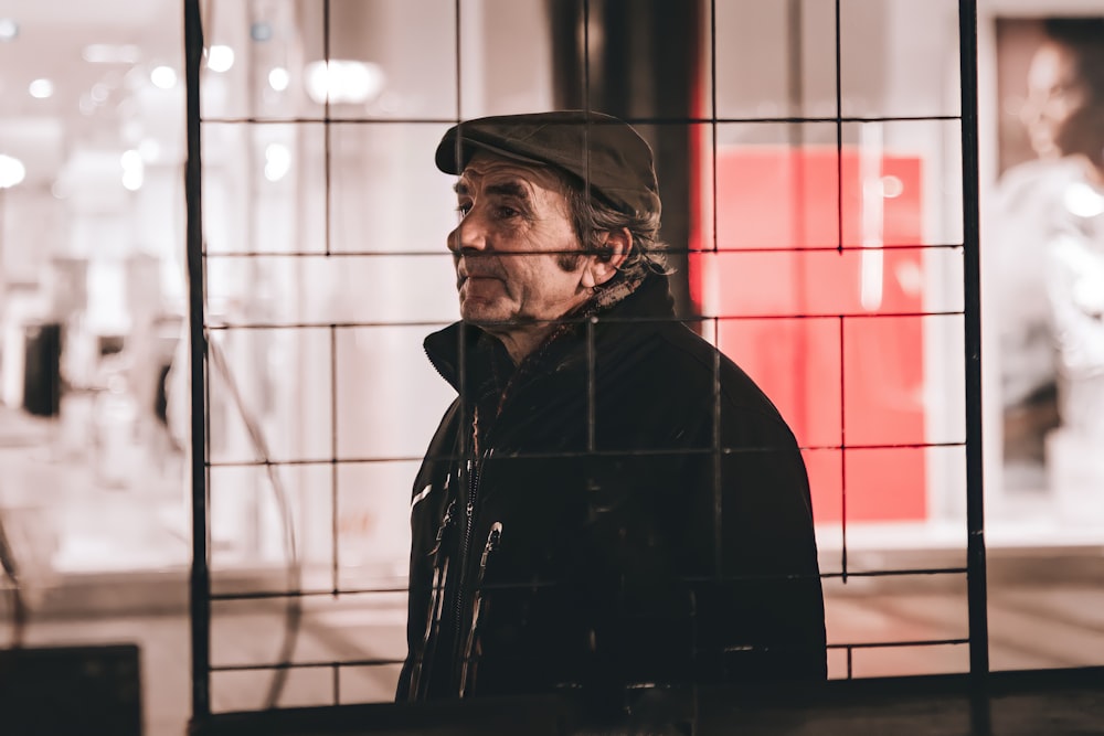 man in black jacket standing near red and white wall