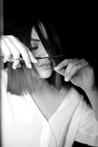A woman cutting her bangs at home.