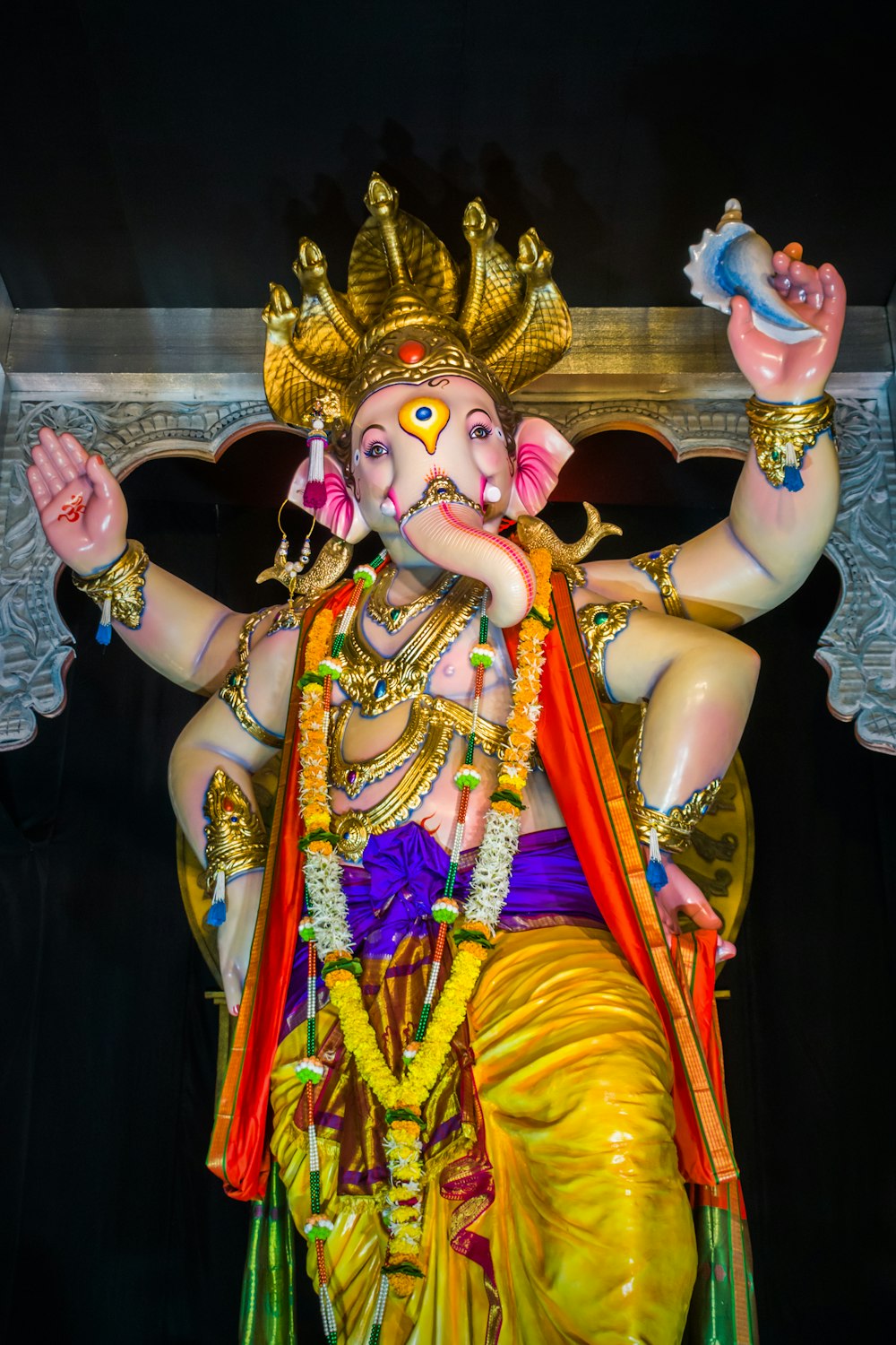 Una estatua de un dios indio con las manos en el aire