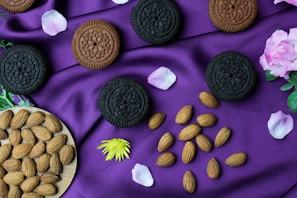 A whimsical arrangement of cookies shaped like school supplies laid out on a white table with a dusty purple accent