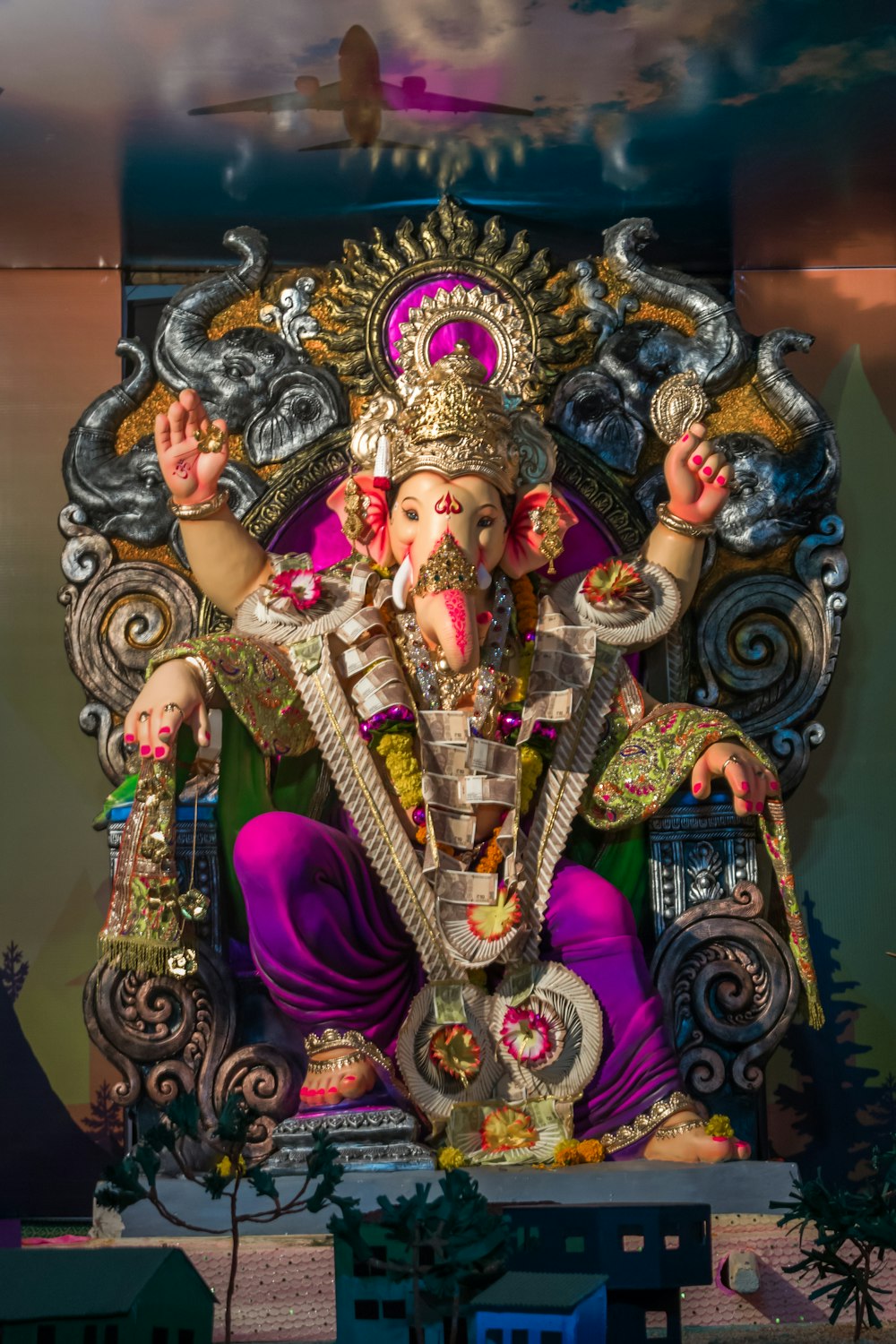 estátua da divindade hindu com coroa roxa e dourada