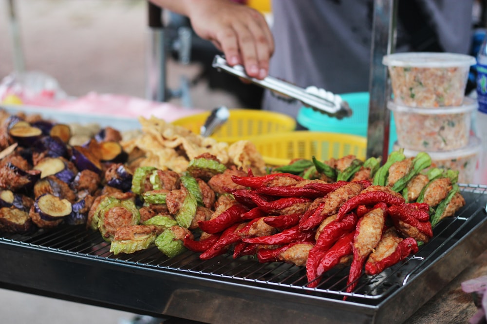 Persona que sostiene un tenedor de acero inoxidable y un cuchillo cortando alimentos cocinados