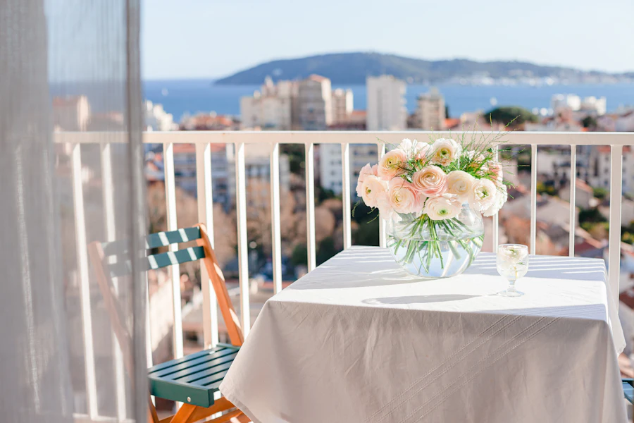 Mesa na varanda com flores e vista para a baía