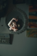woman in white and black long sleeve shirt covering her face with her hands