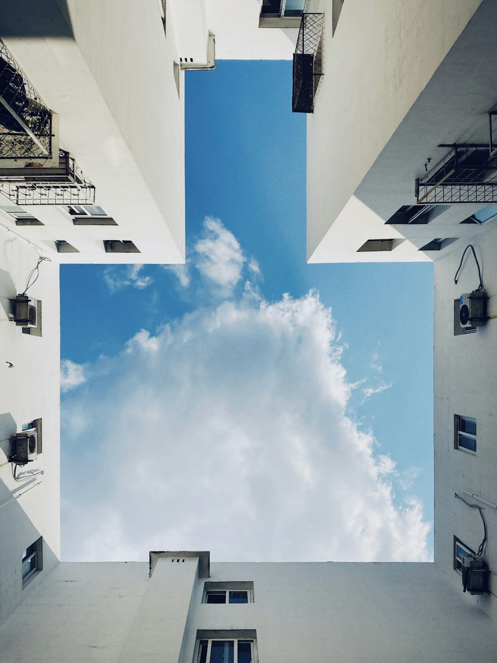 white concrete building under white clouds and blue sky during daytime