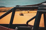 A jeep safari crossing rugged desert terrain with distant mountains on the horizon.