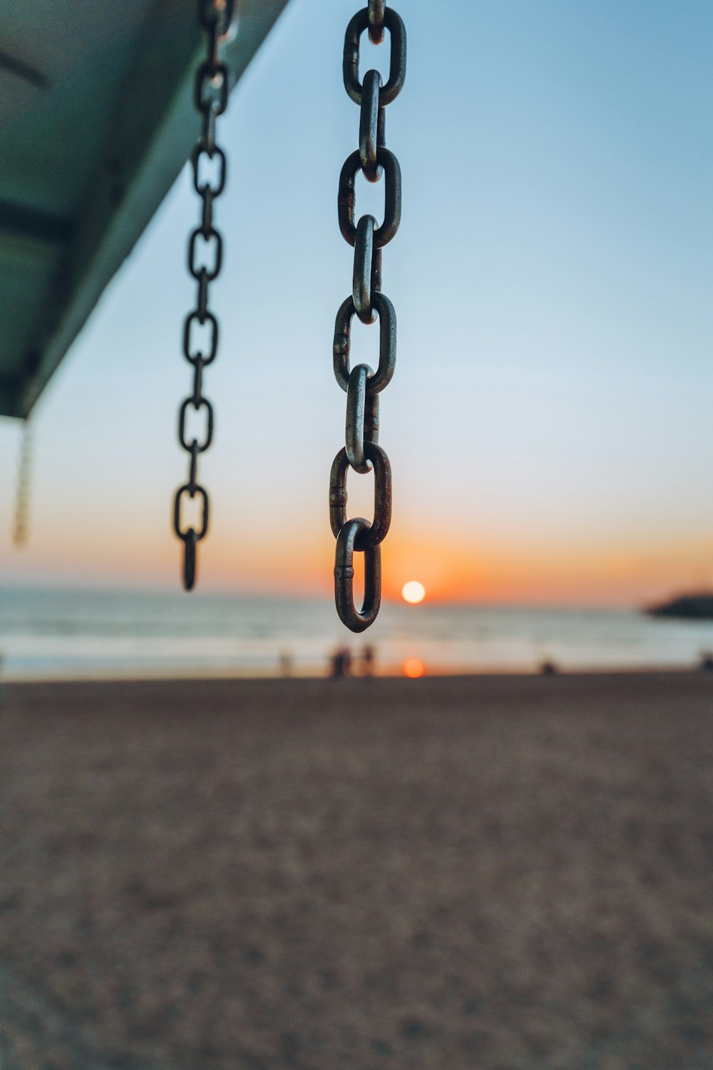 black metal chain on beach during sunset