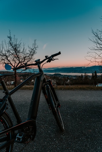 black bicycle on gray asphalt road during daytime