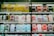Shelves display a variety of smartphone cases in multiple colors, arranged in an organized manner within a store. A sign in Cyrillic characters and advertisements for mobile network plans are visible above the cases.