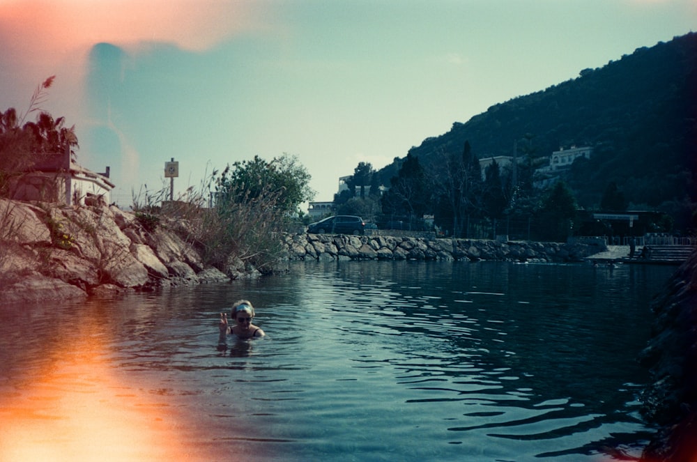 people swimming on lake during daytime