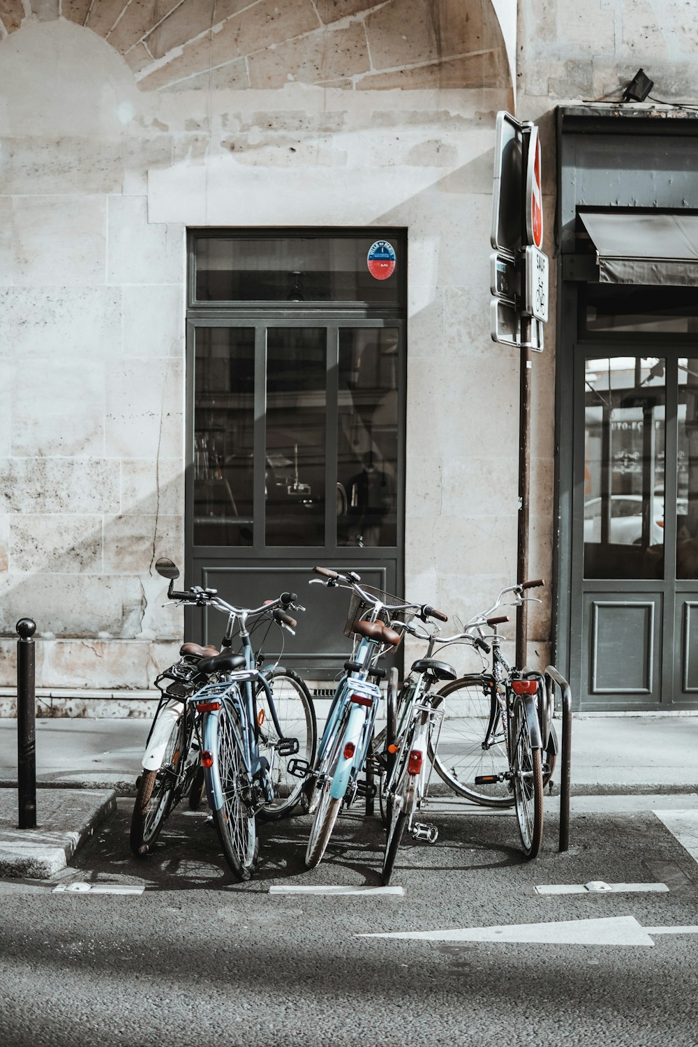 blue and white city bike parked beside brown concrete building during daytime