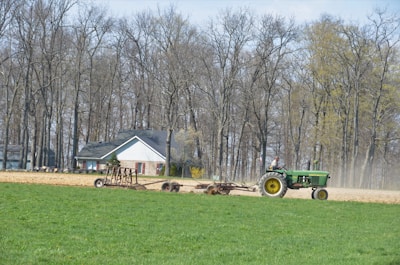 A farmer driving a tractor in a field.