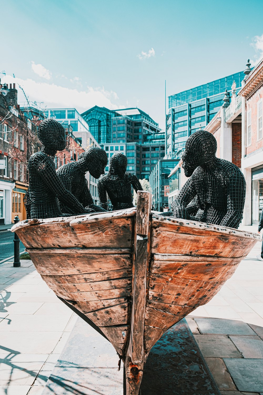 people in a brown wooden boat on a sunny day