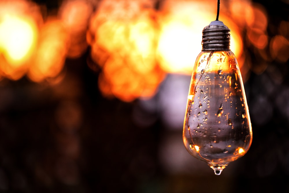 clear glass pendant lamp turned on in bokeh photography