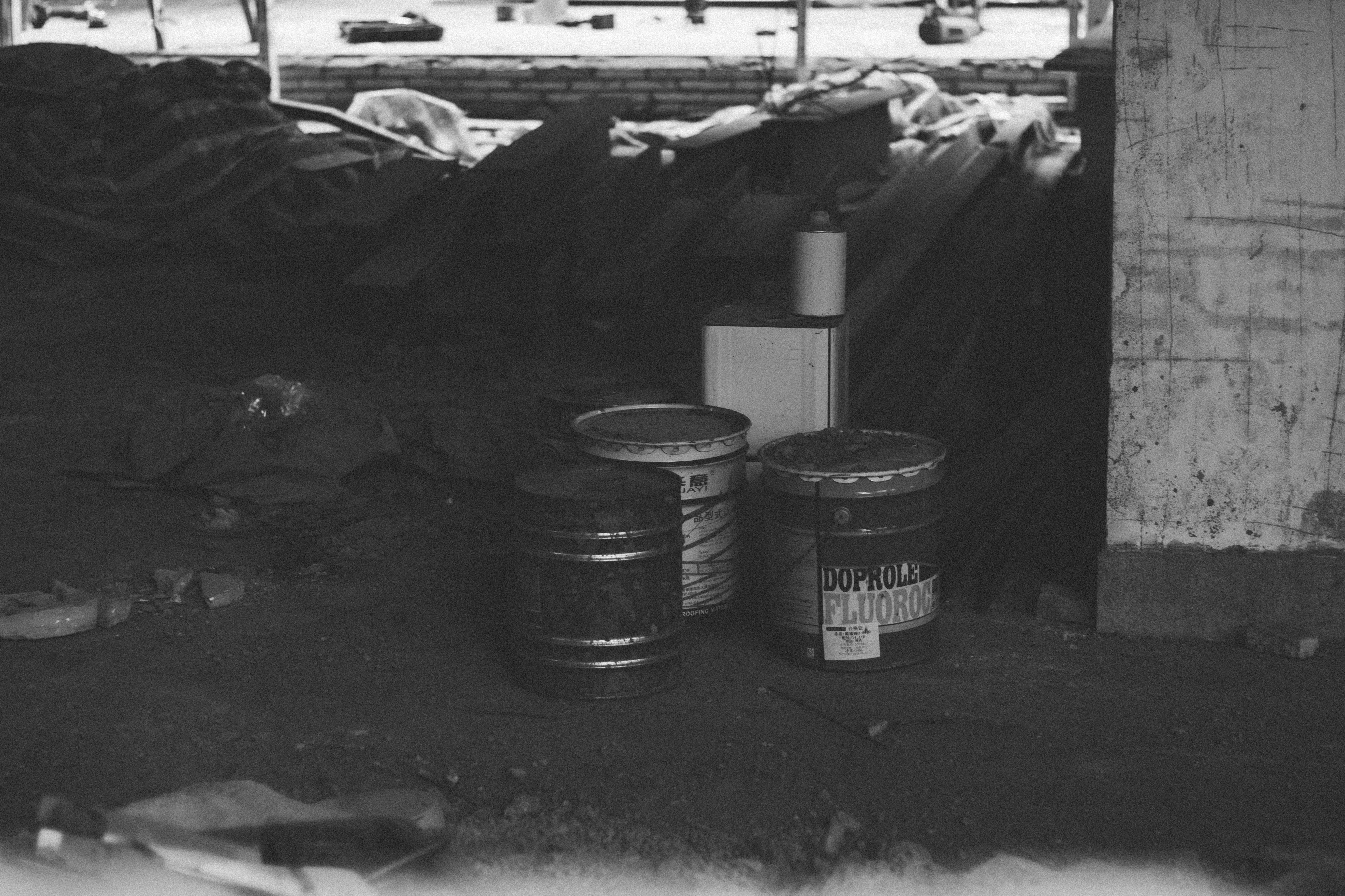 grayscale photo of cans on the floor