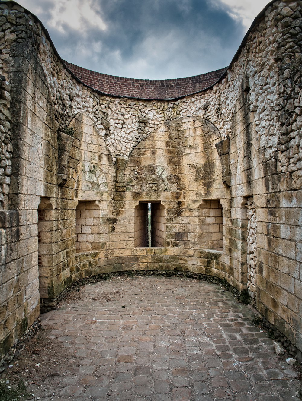 muro di mattoni marroni sotto il cielo blu durante il giorno