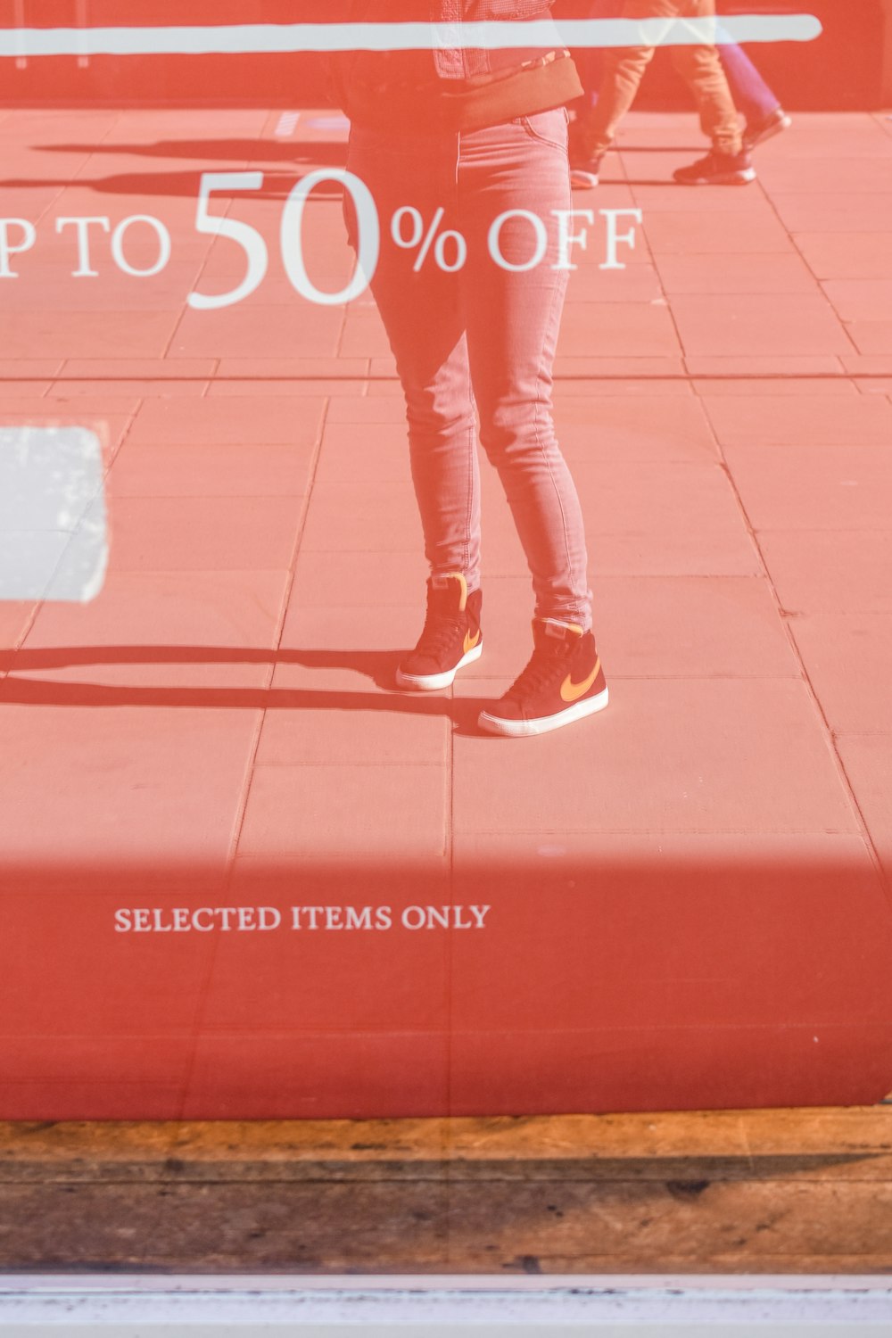 woman in red pants and white shoes standing on red floor