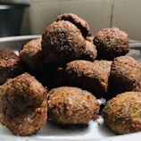 Close-up of a colorful falafel platter with fresh herbs and tahini drizzle.