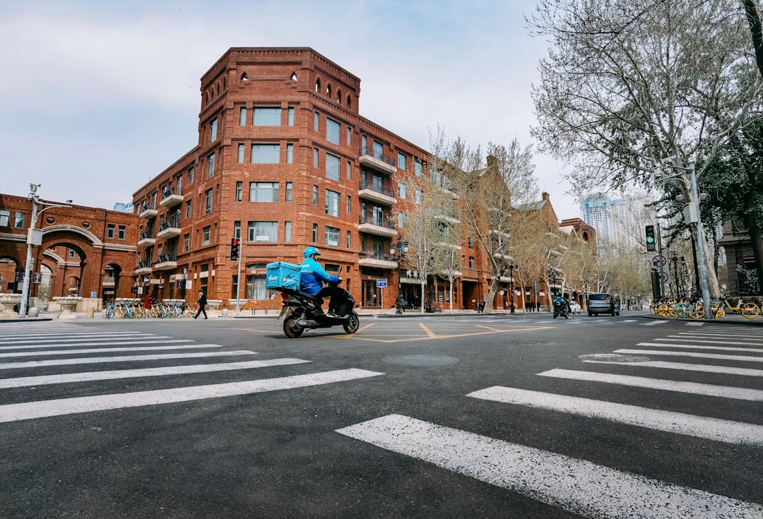 man in blue jacket riding motorcycle on road during daytime