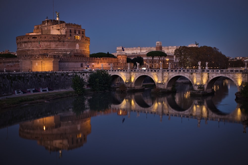 edificio in cemento marrone vicino allo specchio d'acqua durante la notte