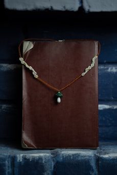 gold necklace on red textile