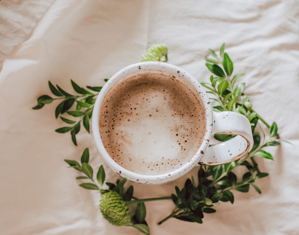 white ceramic mug with brown liquid