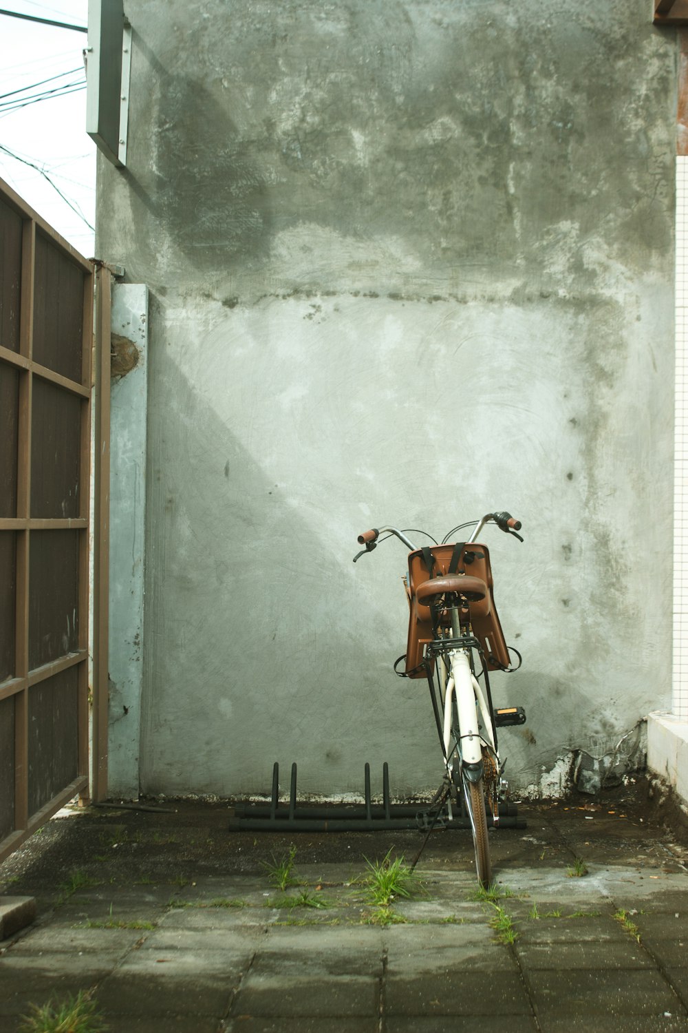 orange and black motorcycle parked beside white wall