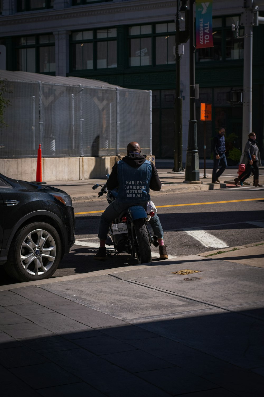 man in black jacket riding black motorcycle on road during daytime