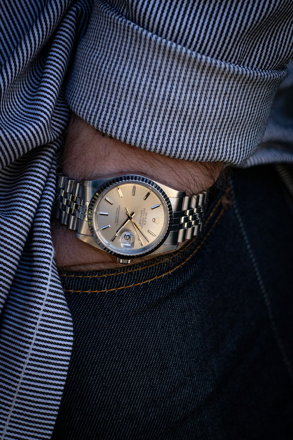 person wearing silver link bracelet round analog watch