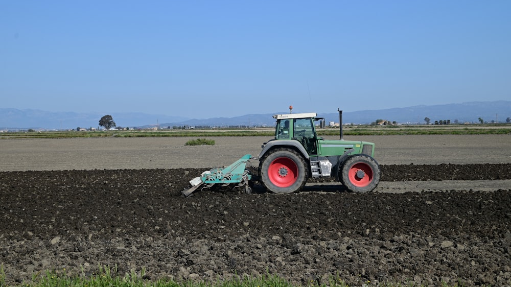 Grüner Traktor tagsüber auf brauner Wiese unter blauem Himmel