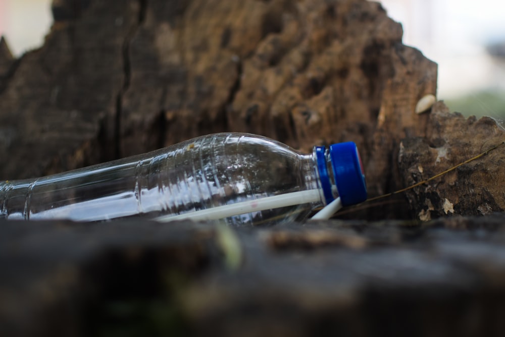 blue and clear glass bottle on brown rock