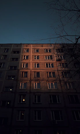 Evening scene capturing the warm glow of the apartment’s exterior lighting.