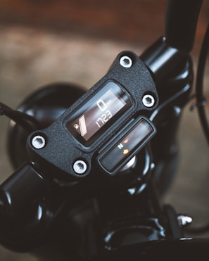 Close-up of a sleek motorcycle dashboard displaying the Veloguard GPS interface glowing in blue.