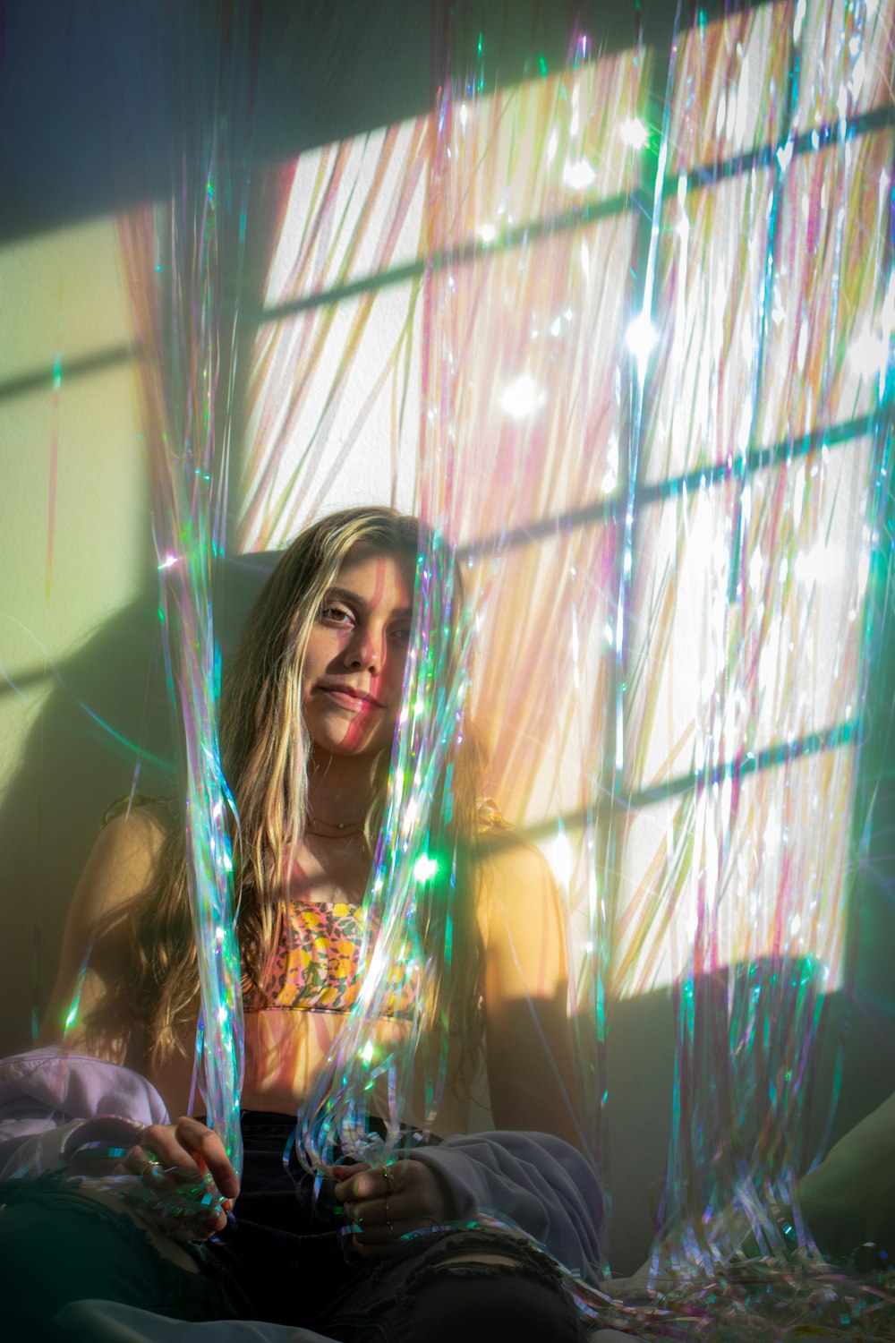 a woman sitting on a bed in front of a window