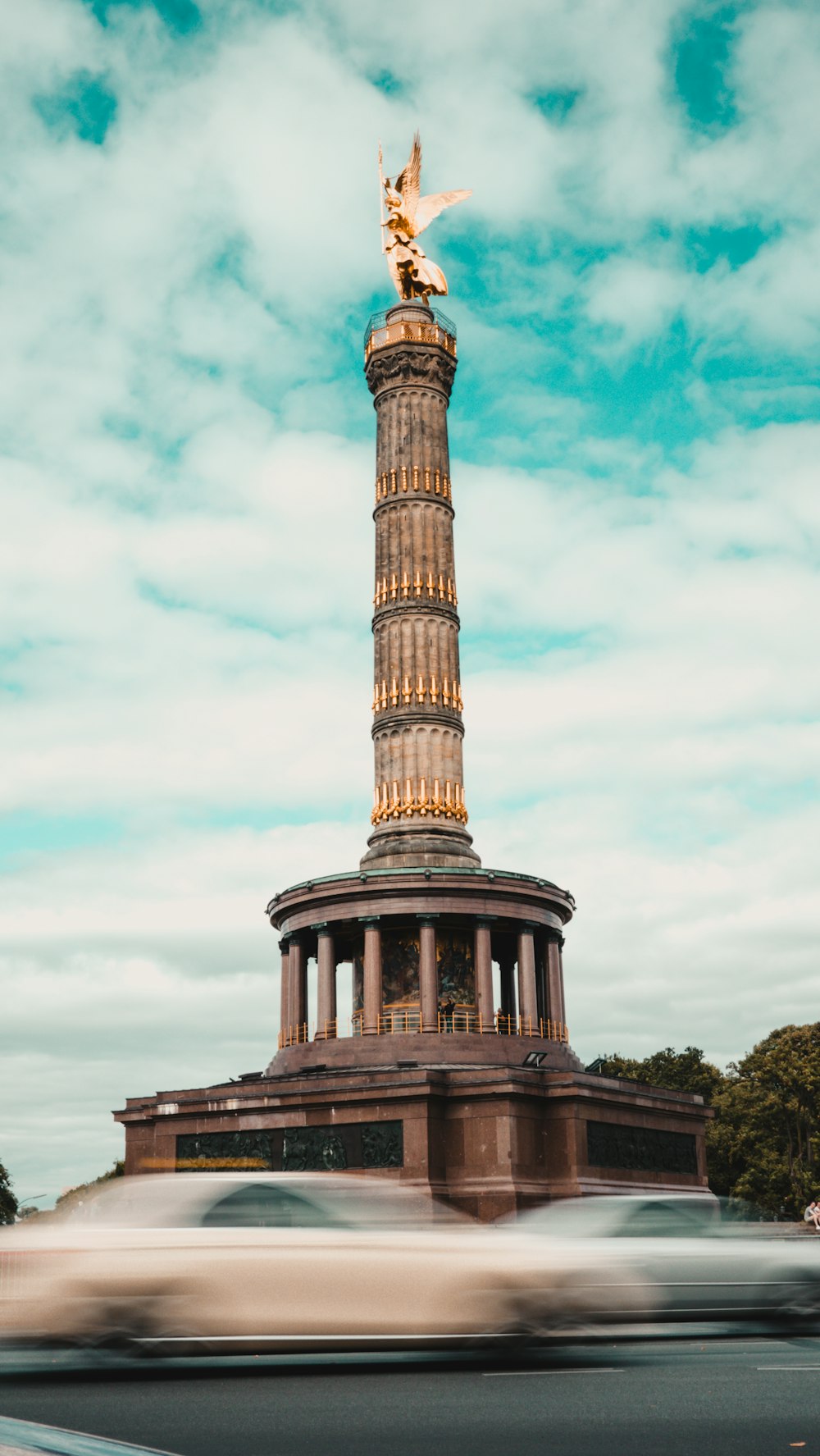 Brauner Betonturm tagsüber unter weißen Wolken