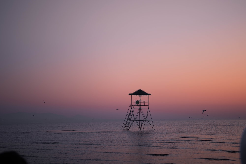 silhouette of a person standing on a wooden dock during sunset