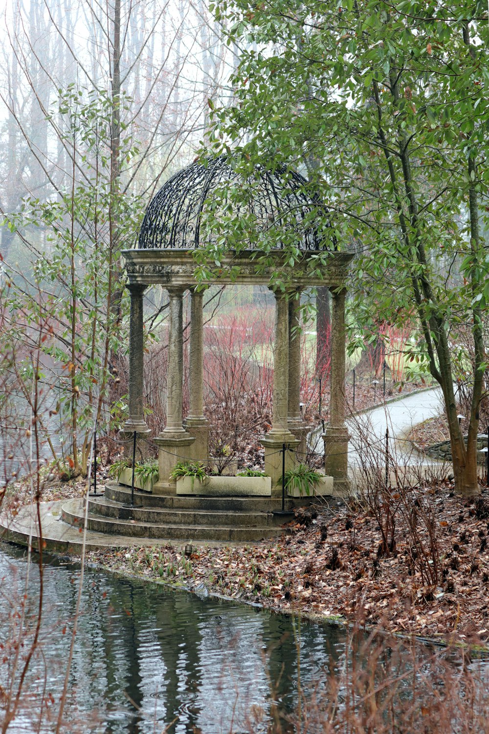 white concrete arch surrounded by trees