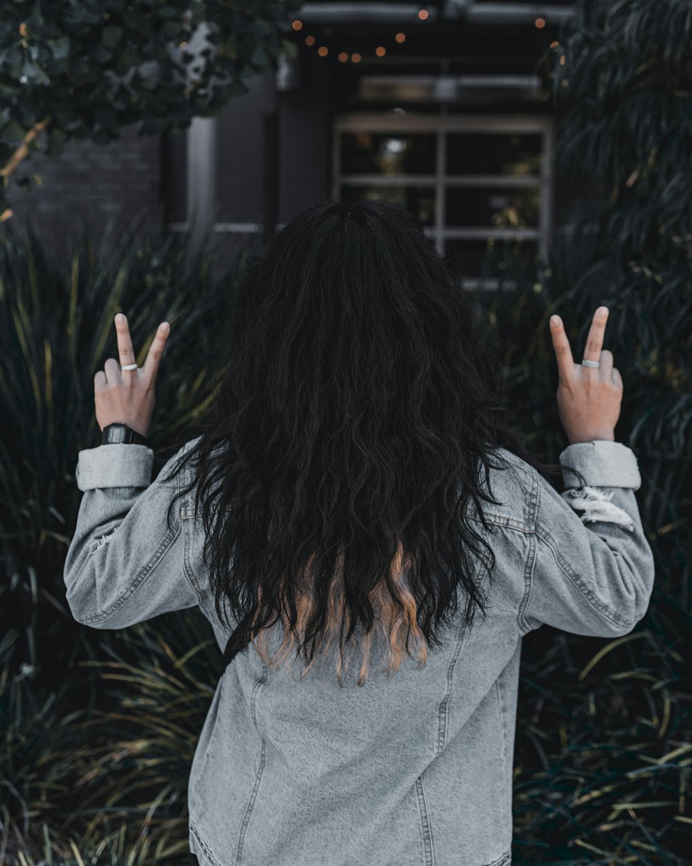 woman in gray long sleeve shirt covering her face with her hands
