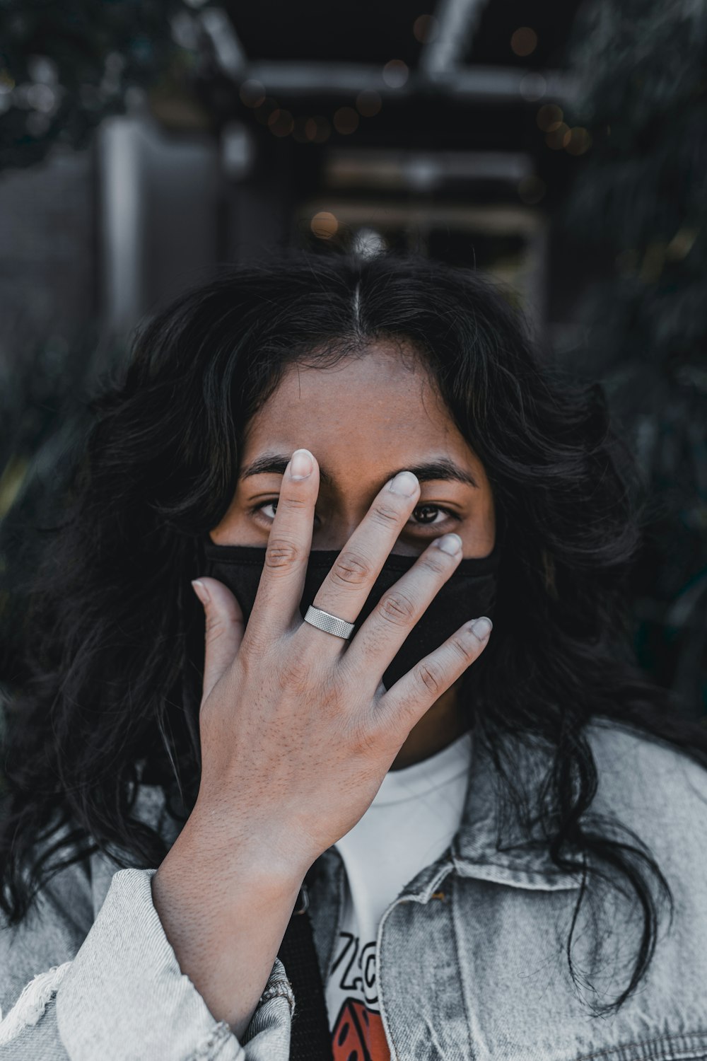 woman in white long sleeve shirt covering her face with her hand