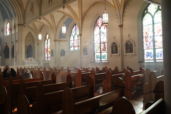 A serene church interior with wooden pews and stained glass windows.