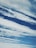 Cloud formations stretch across a rich blue sky, with varying textures and patterns creating a dynamic and serene scene.