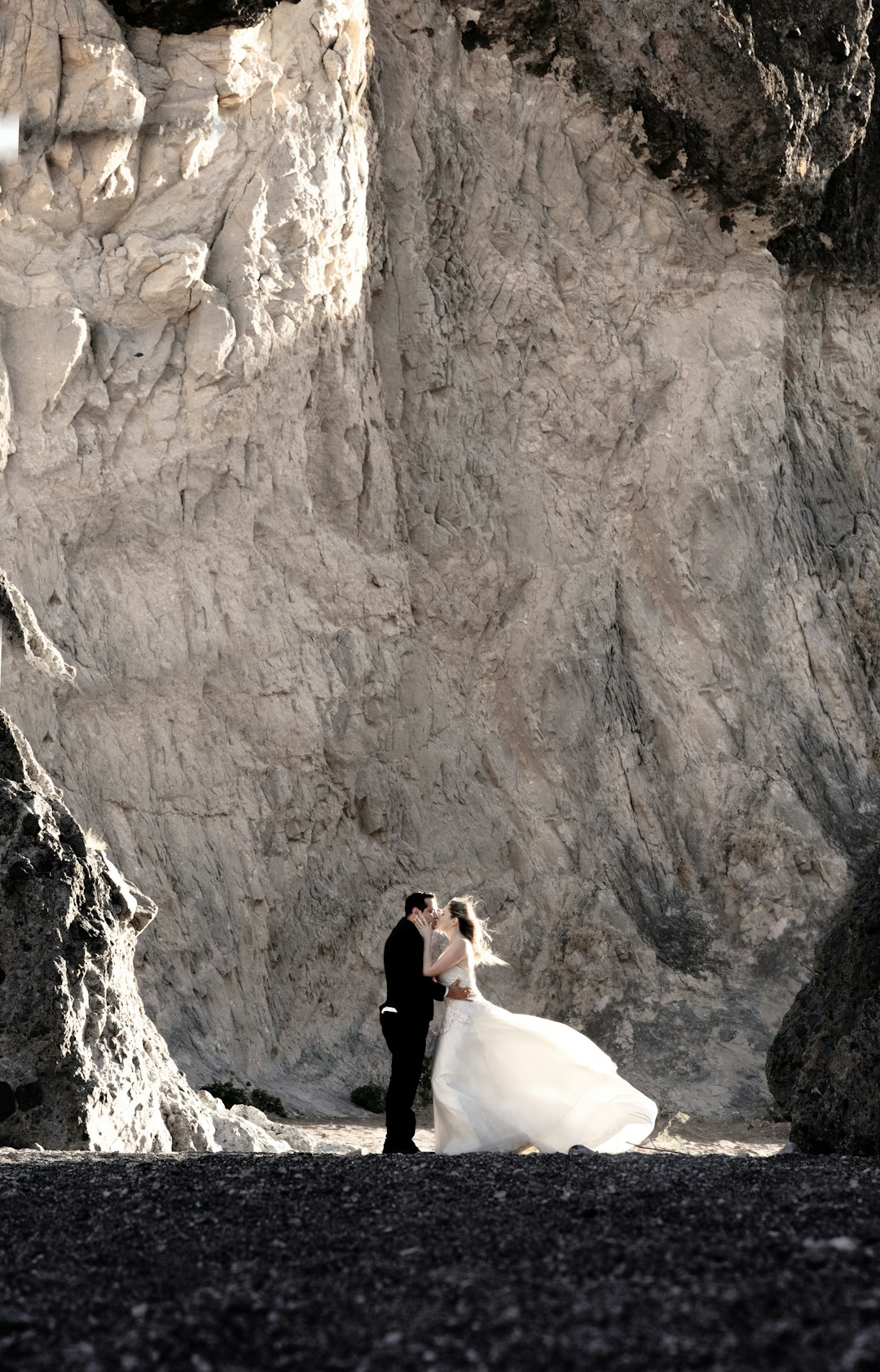 woman in black jacket sitting on rock formation during daytime