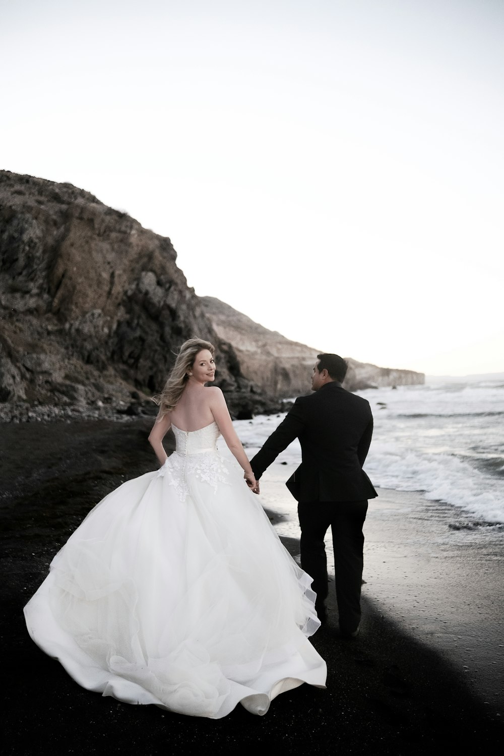 Ein Brautpaar geht am Strand spazieren