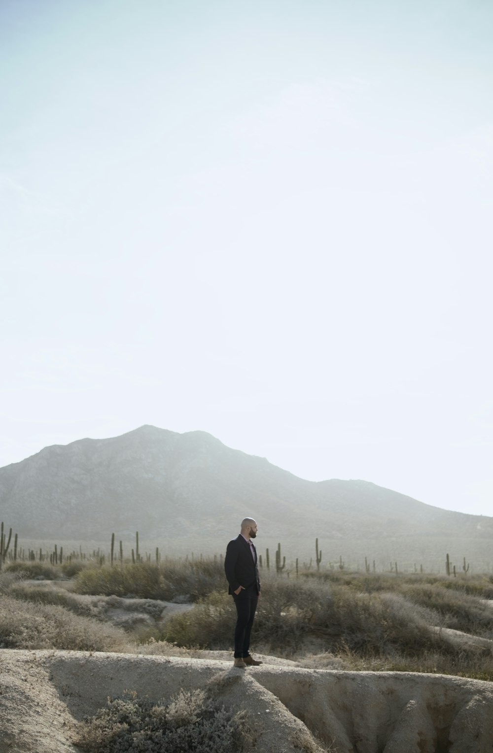 man in black jacket standing on green grass field during daytime